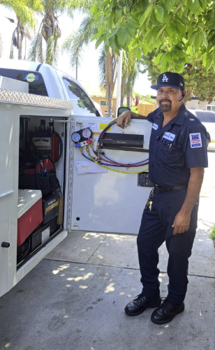 The Battery Man standing beside his mobile automotive battery and A/C service truck.
