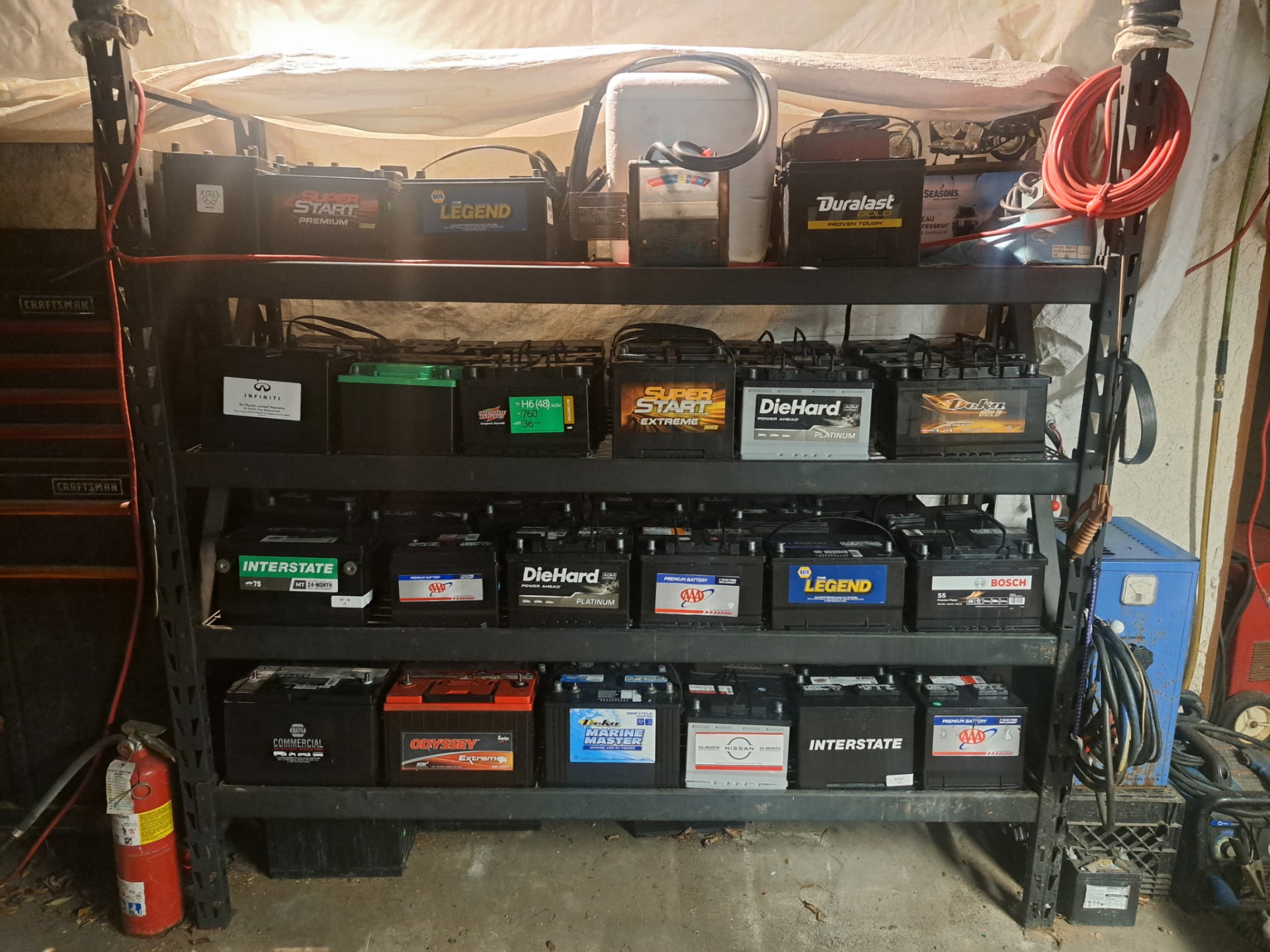 Shelves stocked with automotive, marine, and commercial batteries